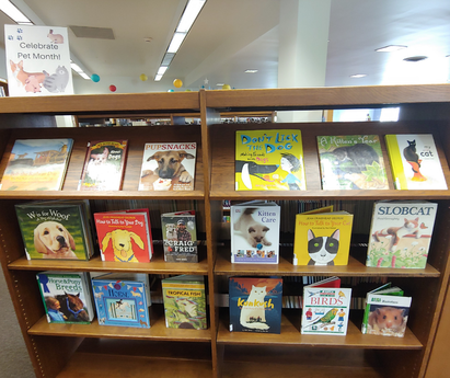 Photo of two book shelves with books about cats and dogs. 