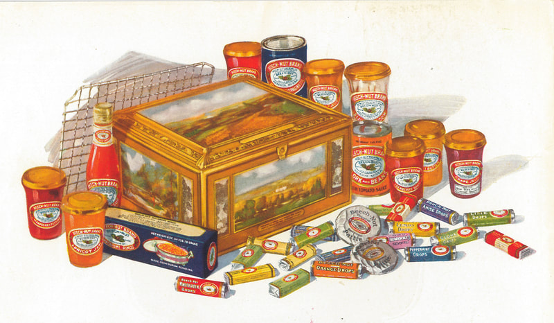 An assortment of things. There is a tin box at the center with landscape scenes on it. There are an assortment of goods surrounding the box including jams, conserves, sliced bacon, Oscar sauce, pasta, candy in rolls, biscuits and a rack for baking. 